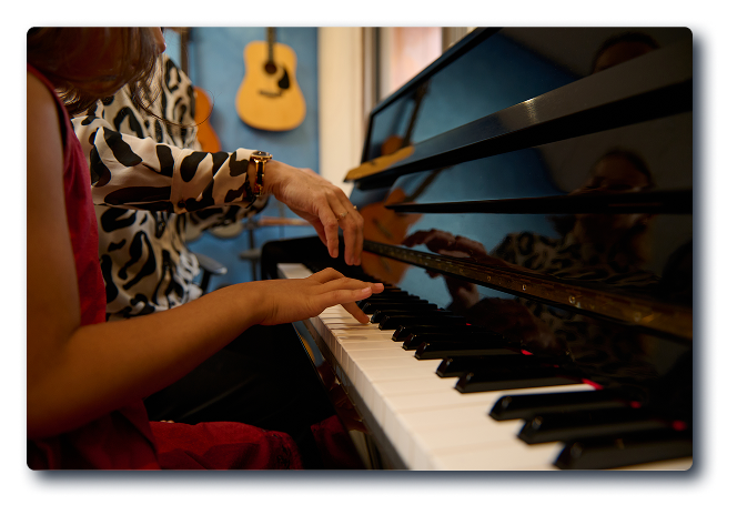 Hands playing piano keys in a music studio, reflecting the collaborative spirit of Christian and Gospel music education at the Museum of Christian & Gospel Music.